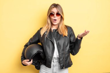 Güzel sarışın kız şok olmuş ve şaşırmış hissediyor. Motosiklet kaskı konsepti