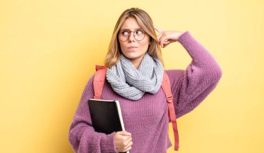 Güzel sarışın kız şaşkın ve kafası karışık, kaşınan bir kafa hissediyor. öğrenci konsepti