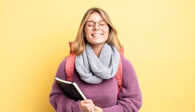 Güzel sarışın kız komik bir şakaya yüksek sesle gülüyor. öğrenci konsepti