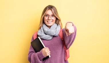 Güzel sarışın kız seni seçen kamerayı işaret ediyor. öğrenci konsepti