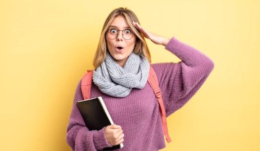 Güzel sarışın kız mutlu, şaşkın ve şaşırmış görünüyor. öğrenci konsepti