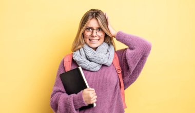 Güzel sarışın kız stresli, endişeli ya da korkmuş, elleri başının üstünde. öğrenci konsepti