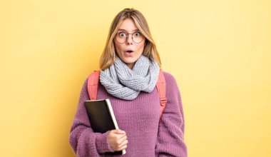 Güzel sarışın kız çok şaşırmış ya da şaşkın görünüyor. öğrenci konsepti