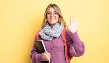 Güzel sarışın kız gülümsüyor ve arkadaş canlısı görünüyor, beş numarayı gösteriyor. öğrenci konsepti