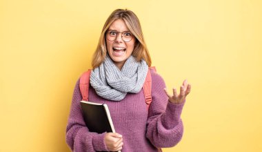 Güzel sarışın kız sinirli, sinirli ve sinirli görünüyor. öğrenci konsepti