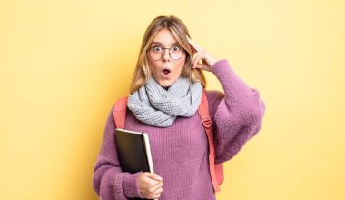 Güzel sarışın kız şaşırmış görünüyor, yeni bir düşünce, fikir ya da konsept fark ediyor. öğrenci konsepti