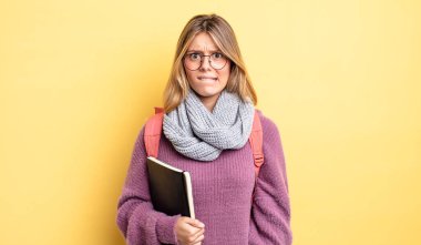 Güzel sarışın kız şaşkın ve şaşkın görünüyor. öğrenci konsepti