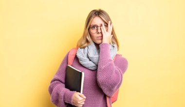 Güzel sarışın kız bıkkın, yorgun ve uykulu hissediyor. öğrenci konsepti