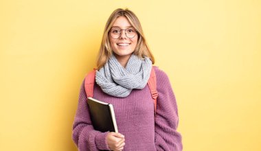 Güzel sarışın kız mutlu ve hoş bir şekilde şaşırmış görünüyor. öğrenci konsepti