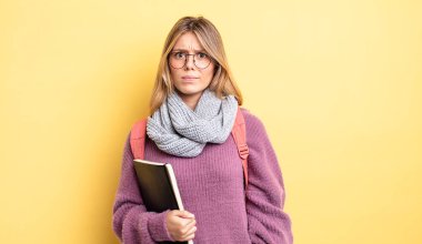 Güzel sarışın kız şaşkın ve şaşkın hissediyor. öğrenci konsepti