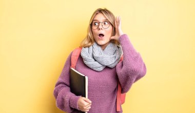 Güzel sarışın kız mutlu, heyecanlı ve şaşırmış hissediyor. öğrenci konsepti