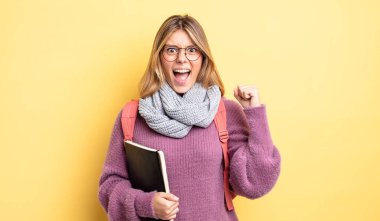 Güzel sarışın kız sinirli bir ifadeyle agresif bir şekilde bağırıyor. öğrenci konsepti