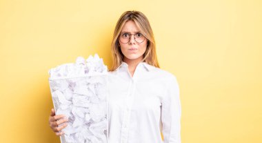 Güzel sarışın kız üzgün, üzgün ya da kızgın ve yana bakıyor. kağıt toplar çöp konsepti