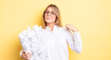 Güzel sarışın kız kibirli, başarılı, pozitif ve gururlu görünüyor. kağıt toplar çöp konsepti