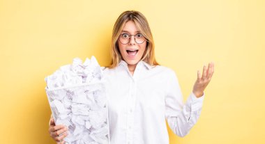 Güzel sarışın kız kendini mutlu hissediyor, bir çözüm ya da fikir bulduğuna şaşırıyor. kağıt toplar çöp konsepti