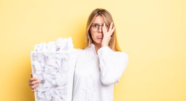 Güzel sarışın kız bıkkın, yorgun ve uykulu hissediyor. kağıt toplar çöp konsepti