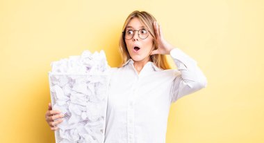 Güzel sarışın kız mutlu, heyecanlı ve şaşırmış hissediyor. kağıt toplar çöp konsepti