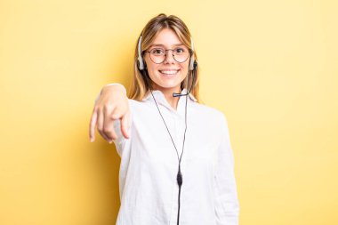 Güzel sarışın kız seni seçen kamerayı işaret ediyor. kulaklık konsepti