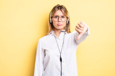 Güzel sarışın kız kendini kötü hissediyor, baş parmağını kaldırıyor. kulaklık konsepti