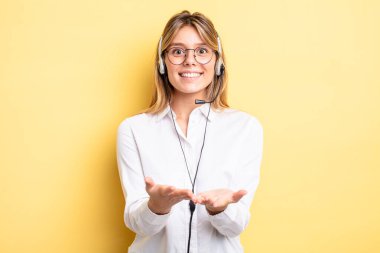Güzel sarışın kız mutlu bir şekilde gülümsüyor ve bir konsept sunuyor. kulaklık konsepti