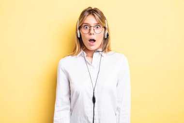 Güzel sarışın kız çok şaşırmış ya da şaşkın görünüyor. kulaklık konsepti