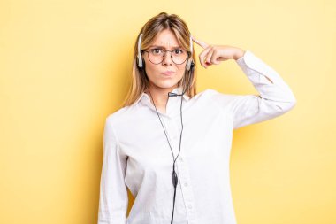 Güzel sarışın kız şaşkın ve şaşkın hissediyor, senin deli olduğunu gösteriyor. kulaklık konsepti