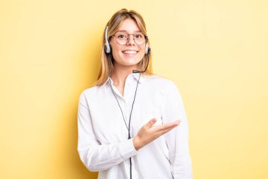 Güzel sarışın kız neşeyle gülümsüyor, mutlu hissediyor ve bir konsept gösteriyor. kulaklık konsepti