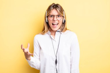 Güzel sarışın kız sinirli, sinirli ve sinirli görünüyor. kulaklık konsepti