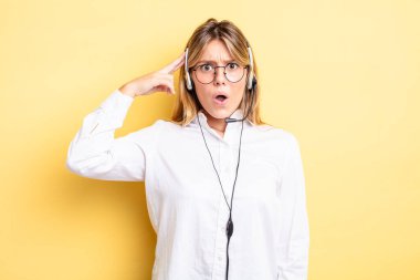 Güzel sarışın kız şaşırmış görünüyor, yeni bir düşünce, fikir ya da konsept fark ediyor. kulaklık konsepti