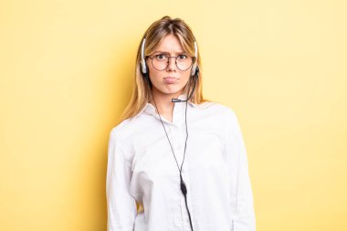 Güzel sarışın kız üzgün ve mızmızlanıyor. Mutsuz bir bakışı var ve ağlıyor. kulaklık konsepti