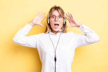 Güzel sarışın kız ellerini havaya kaldırarak çığlık atıyor. kulaklık konsepti