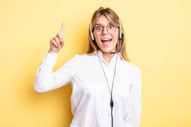 Güzel sarışın kız bir fikri fark ettikten sonra mutlu ve heyecanlı bir dahi gibi hissediyor. kulaklık konsepti