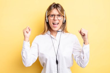 Güzel sarışın kız sinirli bir ifadeyle agresif bir şekilde bağırıyor. kulaklık konsepti