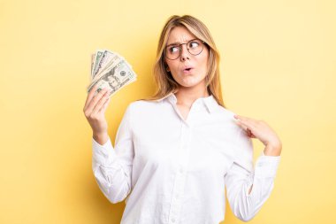 Güzel sarışın kız stresli, endişeli, yorgun ve hayal kırıklığına uğramış hissediyor. Dolar banknotları konsepti