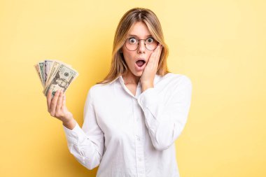 Güzel sarışın kız şok olmuş ve korkmuş hissediyor. Dolar banknotları konsepti