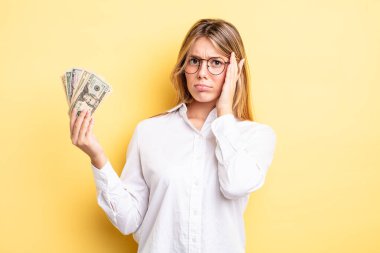 Güzel sarışın kız bıkkın, yorgun ve uykulu hissediyor. Dolar banknotları konsepti