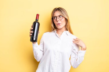 Güzel sarışın kız stresli, endişeli, yorgun ve hayal kırıklığına uğramış hissediyor. şarap şişesi konsepti