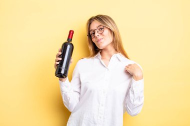 Güzel sarışın kız kibirli, başarılı, pozitif ve gururlu görünüyor. şarap şişesi konsepti