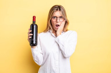 Güzel sarışın kız şok olmuş ve korkmuş hissediyor. şarap şişesi konsepti