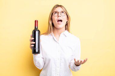 Güzel sarışın kız umutsuz, sinirli ve stresli görünüyor. şarap şişesi konsepti