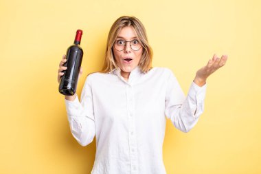 Güzel sarışın kız şok olmuş ve şaşırmış hissediyor. şarap şişesi konsepti