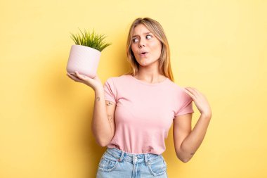 Güzel sarışın kız stresli, endişeli, yorgun ve hayal kırıklığına uğramış hissediyor. ev bitkisi kavramı