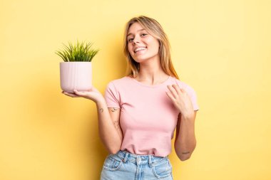Güzel sarışın kız kibirli, başarılı, pozitif ve gururlu görünüyor. ev bitkisi kavramı