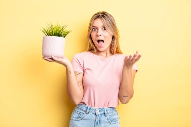 Güzel sarışın kız inanılmaz bir sürprizle şaşkına döndü ve hayrete düştü. ev bitkisi kavramı