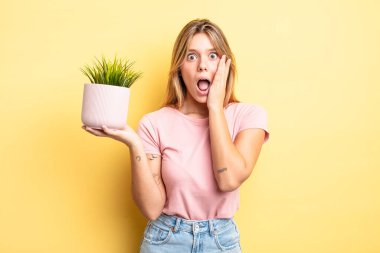 Güzel sarışın kız şok olmuş ve korkmuş hissediyor. ev bitkisi kavramı