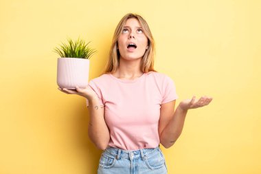 Güzel sarışın kız umutsuz, sinirli ve stresli görünüyor. ev bitkisi kavramı