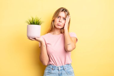 Güzel sarışın kız bıkkın, yorgun ve uykulu hissediyor. ev bitkisi kavramı