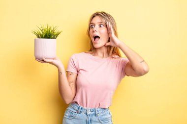 Güzel sarışın kız mutlu, heyecanlı ve şaşırmış hissediyor. ev bitkisi kavramı