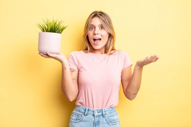 Güzel sarışın kız şok olmuş ve şaşırmış hissediyor. ev bitkisi kavramı