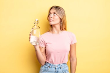 Profil görünümündeki güzel sarışın kız hayal mi kuruyor, hayal mi kuruyor yoksa hayal mi kuruyor? su şişesi kavramı